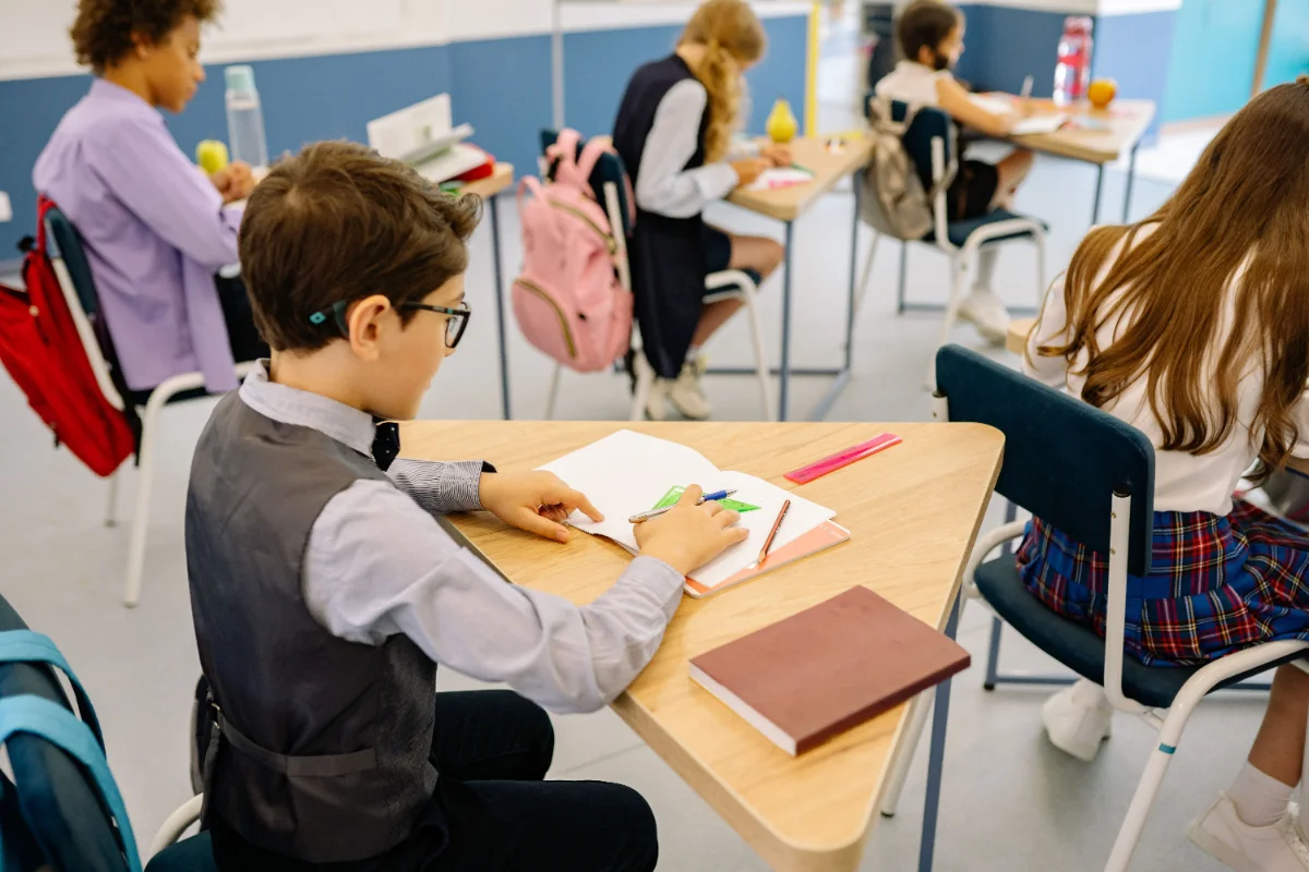 A group of students actively participating in a classroom learning session, focused on their work.
